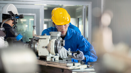 Mechanic operate lathe grinding machine with safety protective device.