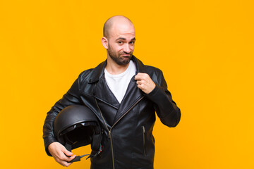 young bald man looking arrogant, successful, positive and proud, pointing to self