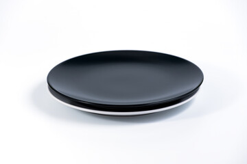 Empty Black and White plates stacked on white background side view