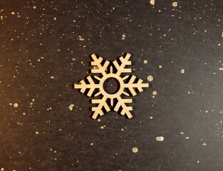 Flocon de neige en bois sur fond or et noir