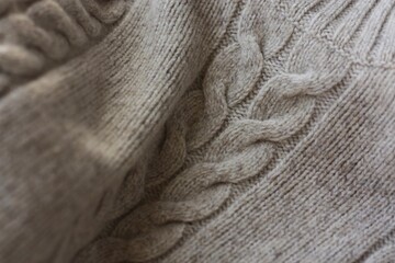 Beautiful beige knitted sweater close up view 