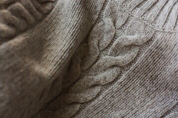 Beautiful beige knitted sweater close up view 