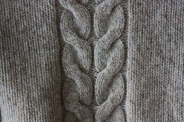 Beautiful beige knitted sweater close up view 