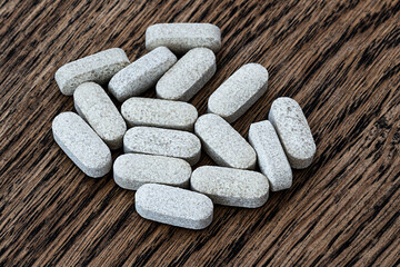 Obraz na płótnie Canvas close-up of ester-c tablets on a wooden background. biologically active supplements selective focus photo.