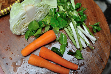 Carrots, Leeks, Cabbage, sprouts, lime leaves in one wooden tray