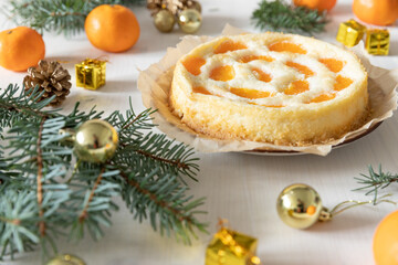 amerikanischer Cheesecake oder Käsekuchen mit  orangen Mandarinen zur Weihnachtszeit im Winter auf...