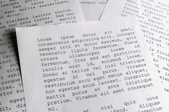 lorem ipsum dolor sit amet concept. selective focus photo of paper sheets with publishing and graphic design placeholder text on them.