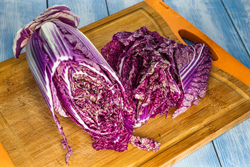 close-up topview of red chinese cabbage, on a wooden board background. selective focus photo of red...