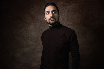 Portrait of a man. The guy in the brown sweater. Portrait on a brown background.