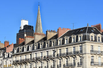 Fototapeta na wymiar Façades immeubles bourgeois Nantes avec Clocher de l'eglise saint Nicolas et tour de Bretagne. France