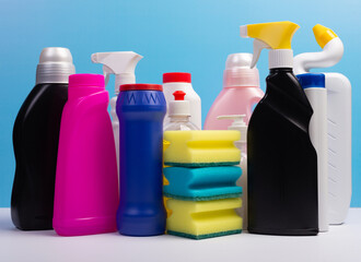 Various cleaning supplies, detergents and cleaning products on blue background