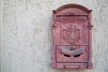 European style red mailbox stuck on a cement wall