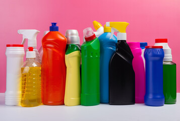 Various cleaning supplies, detergents and cleaning products on pink background