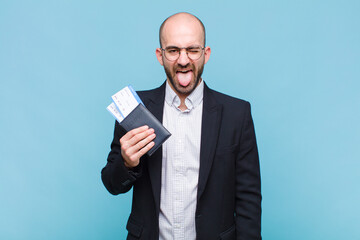 young bald man with cheerful, carefree, rebellious attitude, joking and sticking tongue out, having...