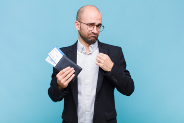 young bald man looking arrogant, successful, positive and proud, pointing to self