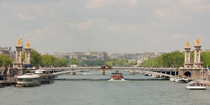  View of the Alexander lll Bridge . By the embankments are moving cars and pedestrians