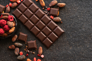Dark chocolate pieces crushed and cocoa beans, culinary background, top view