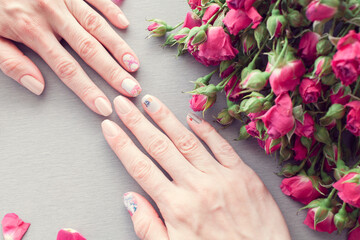 Female hands with art nail manicure and small pink roses