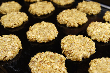 Raw homemade oatmeal cookies on a baking sheet