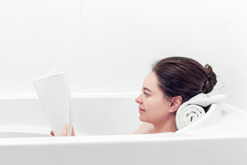 Obraz na płótnie Canvas girl takes a bath while reading a book
