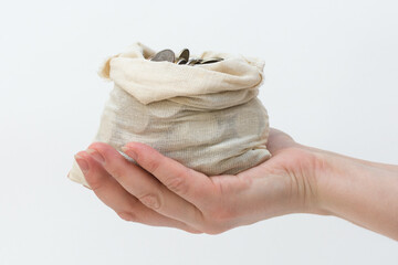 on the human palm lies an open bag of coins. Concept - finance, savings, purchases, investments....
