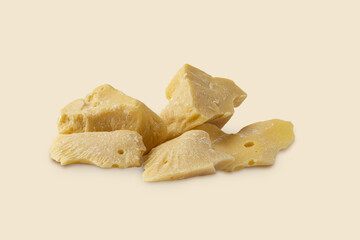 Pieces of natural cocoa butter close-up on a light beige background