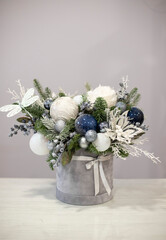 Christmas bouquet in round box. White and blue decor, Christmas tree decorations with fir branches. Gift box for Christmas.