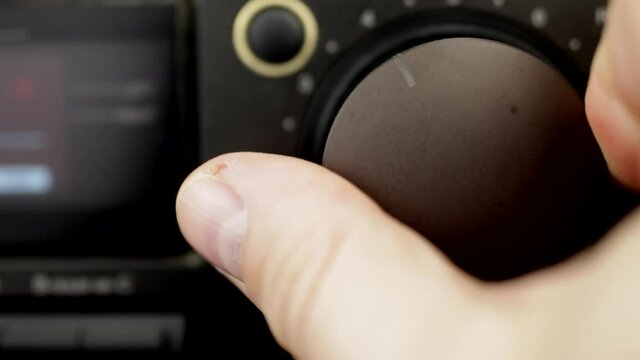 The guy adjusts the recording level on the tape recorder, close-up, selective focus.