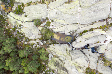 Landscape with rocks and small waterfalls in the black lagoon of the town of Neila, Las calderas, seen from a drone.