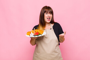 plus size woman looking angry, annoyed and frustrated screaming wtf or what’s wrong with you