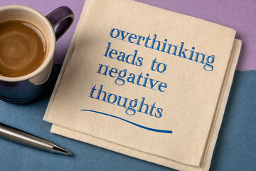 Overthinking leads to negative thoughts - handwriting on a napkin with a cup of coffee, procrastination, mindset and personal development concept