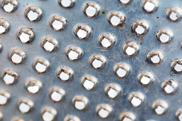 Old rusty metal grater closeup. Stainless steel background with holes.
