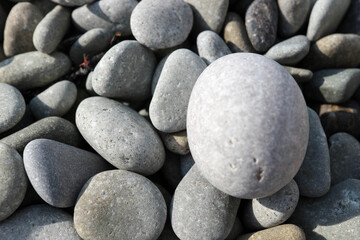 smooth and beautiful pebbles on the beach in the sunlight close up