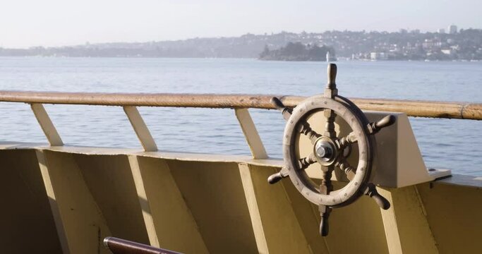 Boat's Wheel On Railings Of Boat Sailing At Port Jackson Bay, Sydney Harbour In Sydney, New South Wales, Australia. - wide shot