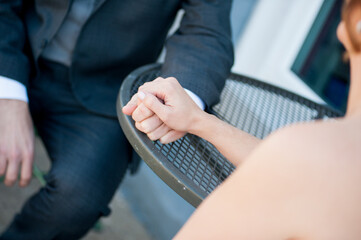 couple holding hands on bistro table