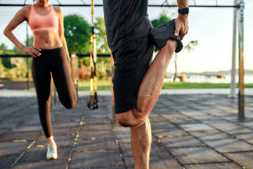 Selective focus on sportsman stretching quadriceps on leg