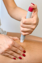 Woman applying shot pen on thigh.