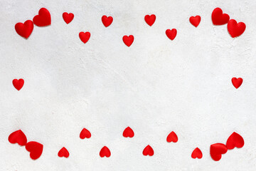 Card to St. Valentine's day with a frame of red textile hearts on a white background. Top view, close-up