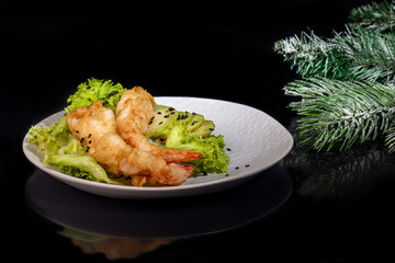 Avocado and king prawns salad on green leaves. Festive dinner New Years concept. Healthy eating. On a black reflective background.