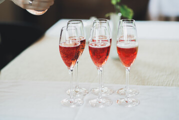 Waiter serving glasses with champagne on a tray