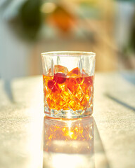 Cocktail Glass with Whiskey or Brown Liquor on Bright Table