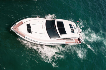 A luxury private motor yacht under way on tropical sea with bow wave.