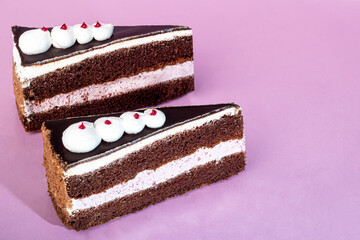 Festive cake with chocolate and cottage cheese layer. Two portions. On a pink background. Birthday, holidays, sweets.