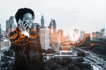 Attractive black businesswoman developer having conference call to protect clients confidential information by inventing solutions. IT lock icons over Kuala Lumpur city background.