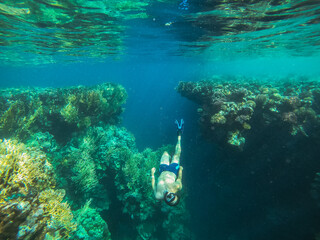 Dive. The guy in the underwater mask and fins dives deep into the sea. Egypt. Red sea.