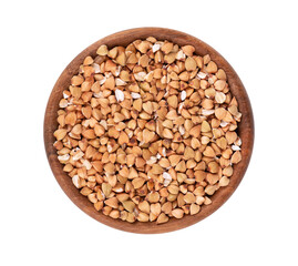 Buckwheat groats in wooden bowl, isolated on white background. Green buckwheat seeds. Top view.