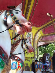 Fototapeta na wymiar Children's plastic carousels in the form of a horse in an amusement park. Summer family vacation.