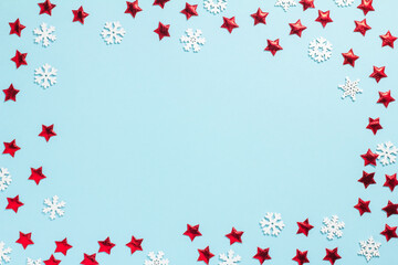 Festive background with red stars and white snowflakes in the form of a frame on a blue background. Christmas, birthday, or party. Christmas, birthday, or party. Flat lay, top view, copy space