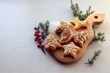  Holiday cookies made by various figures-Christmas trees, snowflakes, moon-on a wooden Board, side view, space for tex