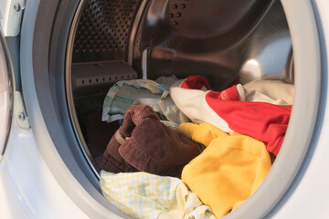 colorful clothes in the washing machine, preparing for washing.